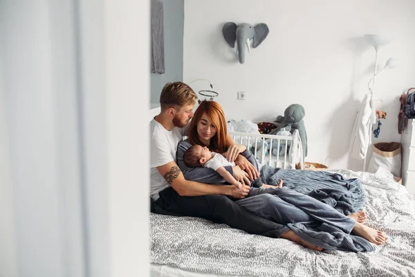 Familia feliz con bebé recién nacido en la cama — Foto de Stock