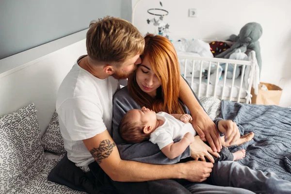 Familia feliz con bebé recién nacido en la cama —  Fotos de Stock