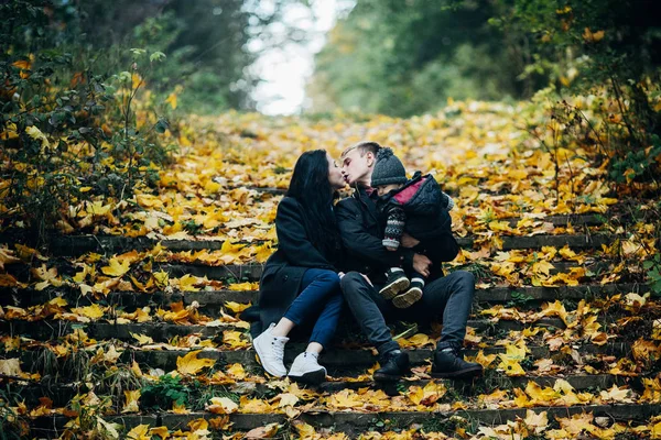 Familia joven e hijo recién nacido en el parque de otoño —  Fotos de Stock