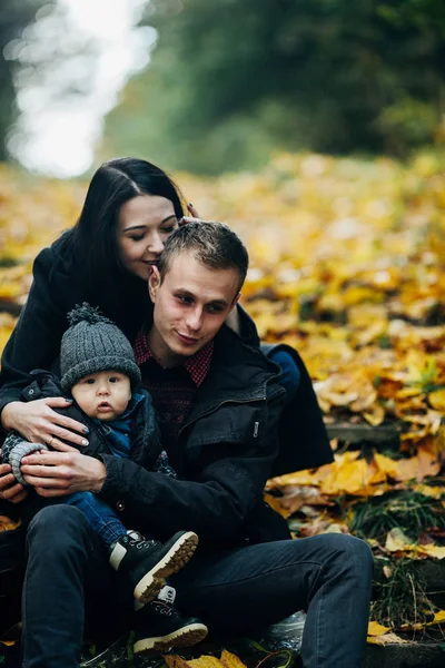 Giovane famiglia e neonato nel parco autunnale — Foto Stock