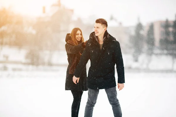 Paar poseren in een besneeuwde park — Stockfoto