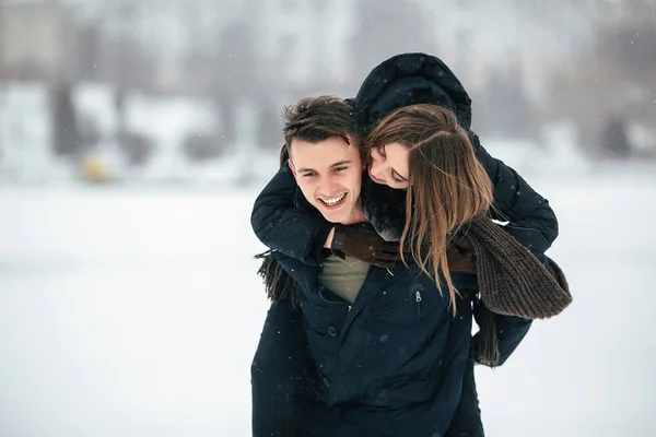 Man carries his girlfriend on the back — Stock Photo, Image