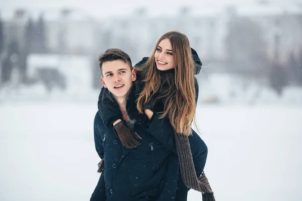 Man draagt zijn vriendin achterop — Stockfoto