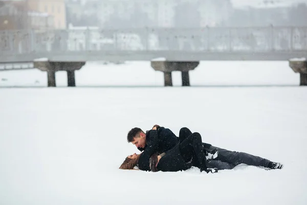 Kız ve adam karda yalan — Stok fotoğraf