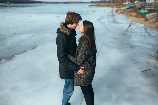 Jovem casal bonito no gelo de um lago congelado — Fotografia de Stock