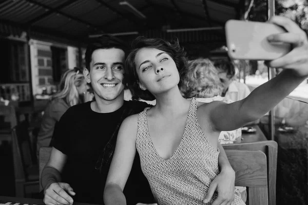 Ragazzo e la ragazza fare selfie nel caffè al di fuori — Foto Stock