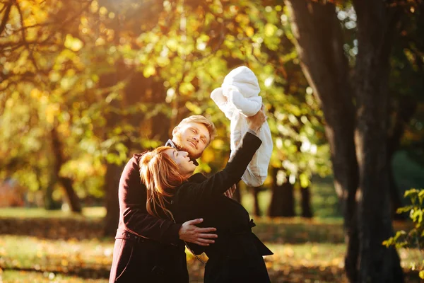 Ung familj och nyfödde son i höst park — Stockfoto