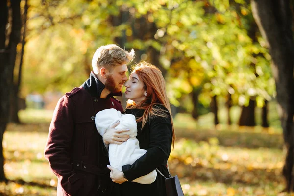 Ung familj och nyfödde son i höst park — Stockfoto