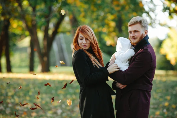 Young family and newborn son in autumn park — Stock Photo, Image