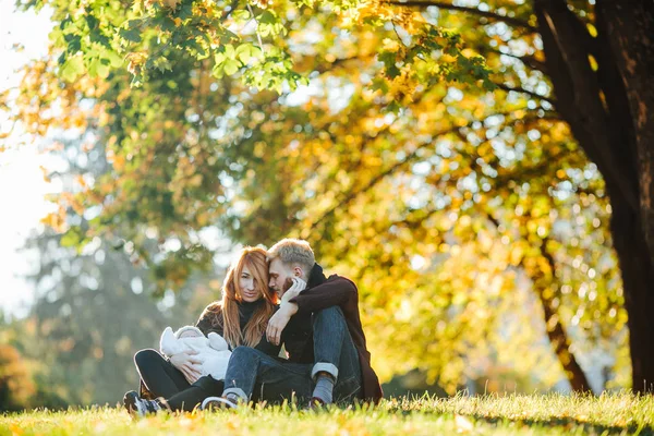 Familia joven e hijo recién nacido en el parque de otoño — Foto de Stock