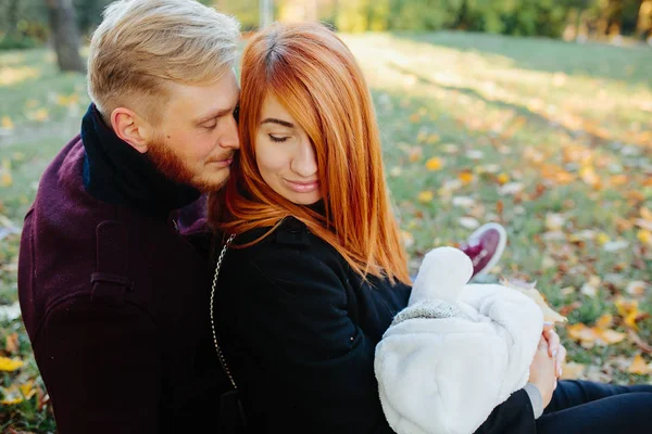Jovem família e filho recém-nascido no parque de outono — Fotografia de Stock