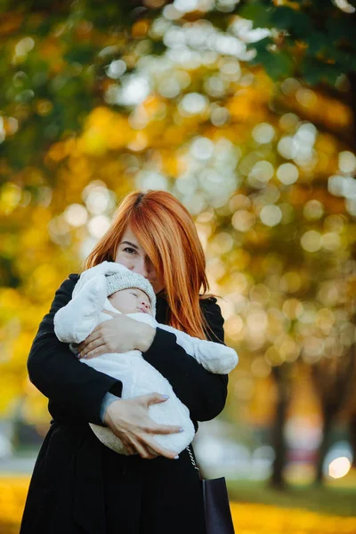 Moeder en pasgeboren zoon in herfst park — Stockfoto