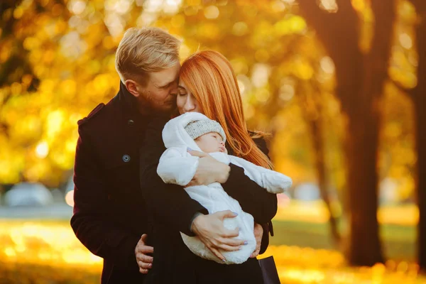 Молода сім'я і новонароджений син в осінньому парку — стокове фото