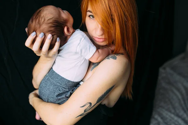 Joven madre mujer sosteniendo a su hijo bebé — Foto de Stock