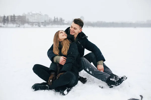 Paar zittend op de sneeuw — Stockfoto