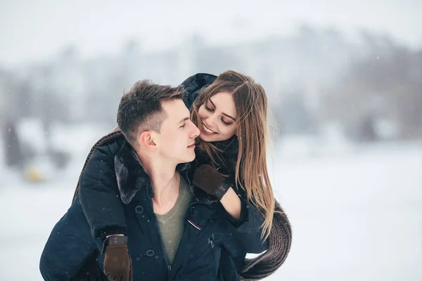 Mannen bär sin flickvän på baksidan — Stockfoto