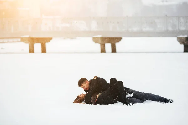 Meisje en jongen liggen op sneeuw — Stockfoto