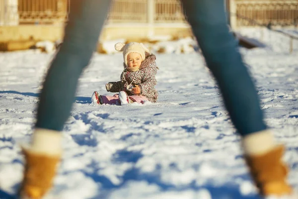 Meisje zittend in de sneeuw — Stockfoto