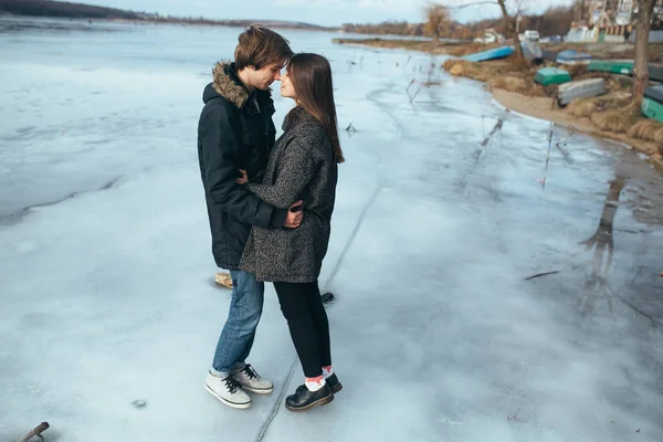 凍った湖の氷の上の若い美しいカップル — ストック写真