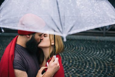 adam ve bir şemsiye altında öpüşme kız