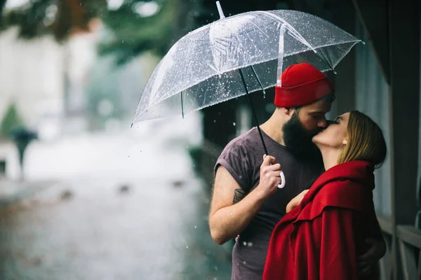 Chico y la chica besándose bajo un paraguas — Foto de Stock