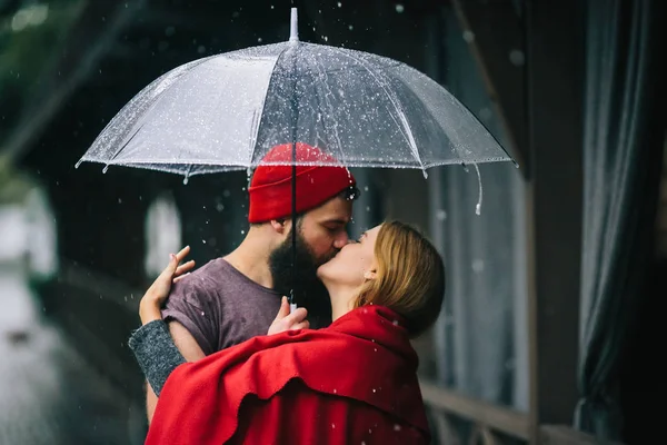 Cara e a menina beijando sob um guarda-chuva — Fotografia de Stock