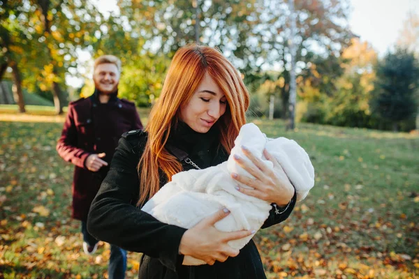 Familia joven e hijo recién nacido en el parque de otoño —  Fotos de Stock