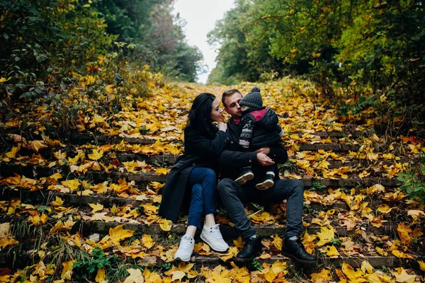 Familia joven e hijo recién nacido en el parque de otoño — Foto de Stock