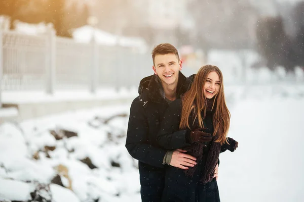 Paar poseren in een besneeuwde park — Stockfoto