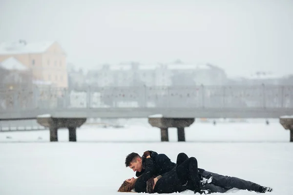 Girl and guy lie on snow