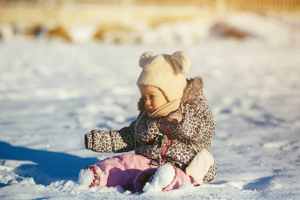 Bambina seduta nella neve — Foto Stock