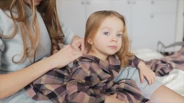 Мати одягає доньку в сукню — стокове відео