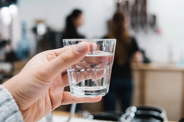 Glas water in de hand — Stockfoto