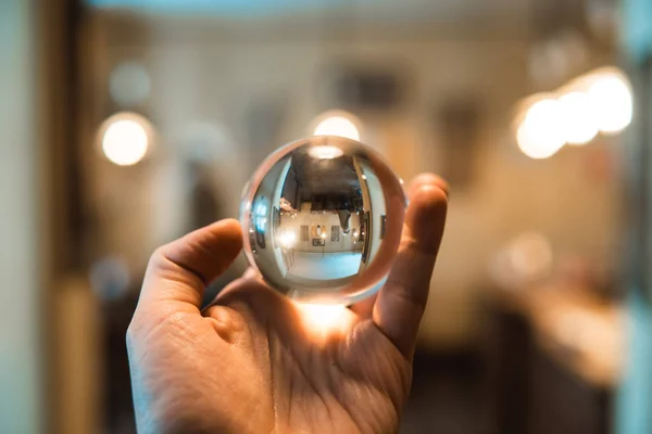 Homme tenant une boule de verre à l'intérieur — Photo