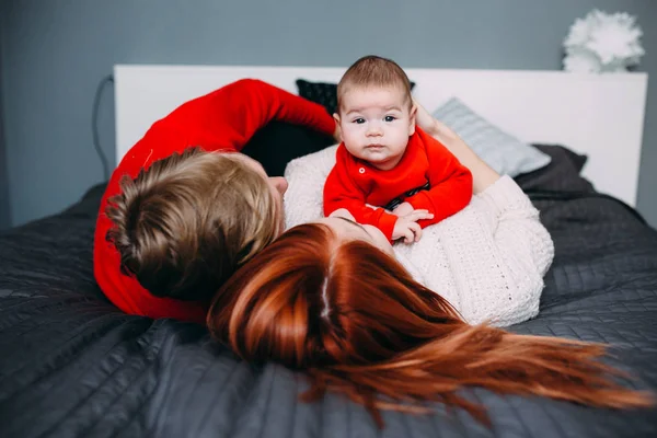 Familia feliz con bebé recién nacido en la cama —  Fotos de Stock