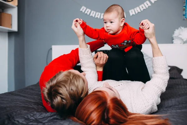 Famiglia felice con neonato sul letto — Foto Stock