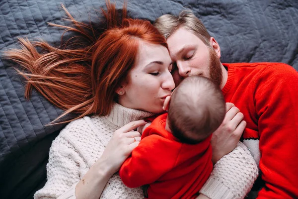 Lycklig familj med nyfödd baby på sängen — Stockfoto