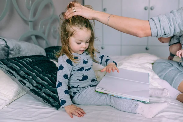 Kleines Mädchen sitzt im Bett — Stockfoto