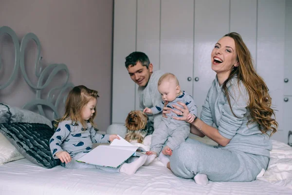 Familjen leker på sängen i sovrummet — Stockfoto