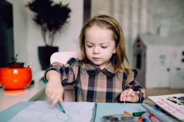 Mutlu küçük kız evde çizim yapıyor.