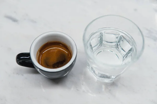 Чашка с кофе рядом со стаканом воды — стоковое фото