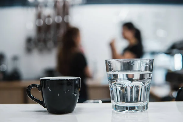 Kopje met koffie bij een glas water — Stockfoto