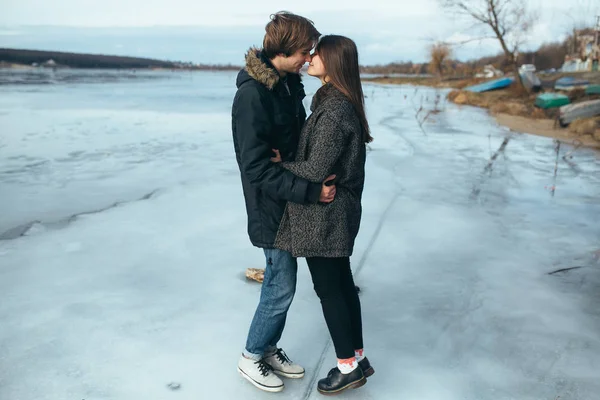 凍った湖の氷の上の若い美しいカップル — ストック写真