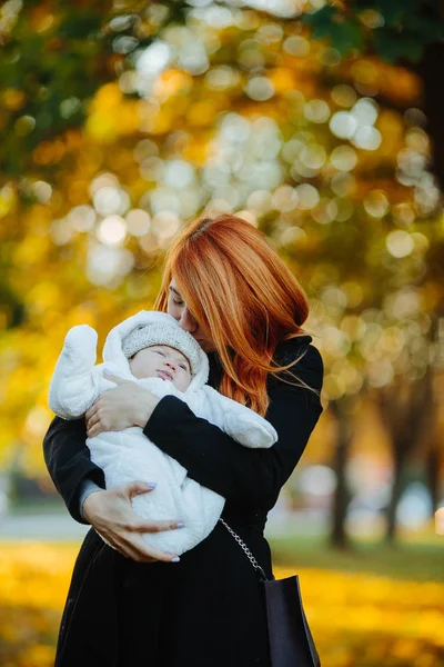 Madre e hijo recién nacido en el parque de otoño — Foto de Stock