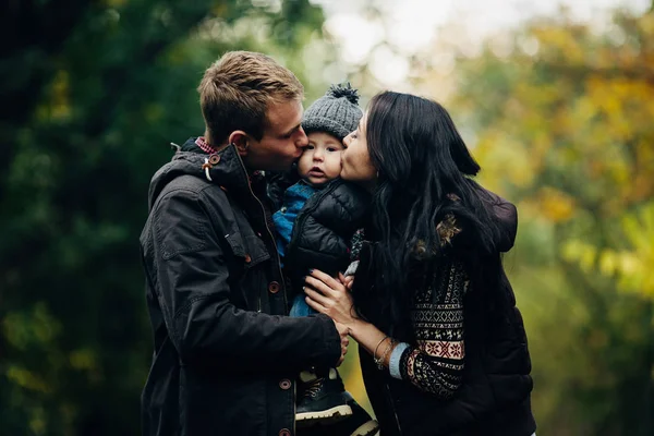 Jong gezin en pasgeboren zoon in herfst park — Stockfoto