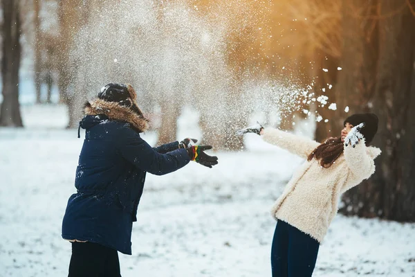 Jongen en meisje spelen met sneeuw — Stockfoto