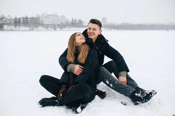 Paar zittend op de sneeuw — Stockfoto