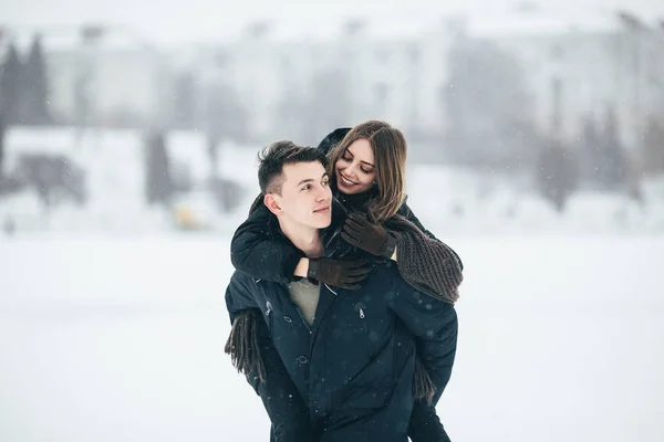 Man draagt zijn vriendin achterop — Stockfoto