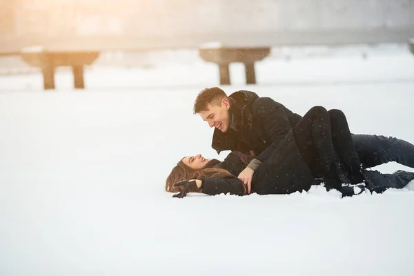 Meisje en jongen liggen op sneeuw — Stockfoto