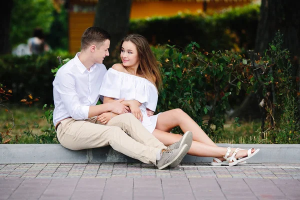 Uomo e donna seduti sul marciapiede — Foto Stock